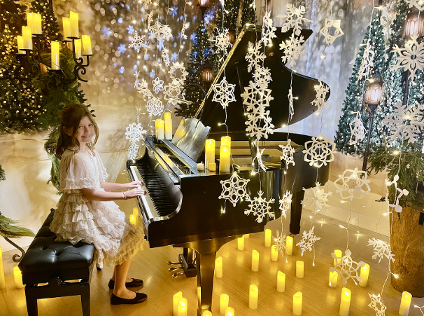Student performing at our Candlelight Holiday Concert in an enchanting forest setting with snowflakes and candles!